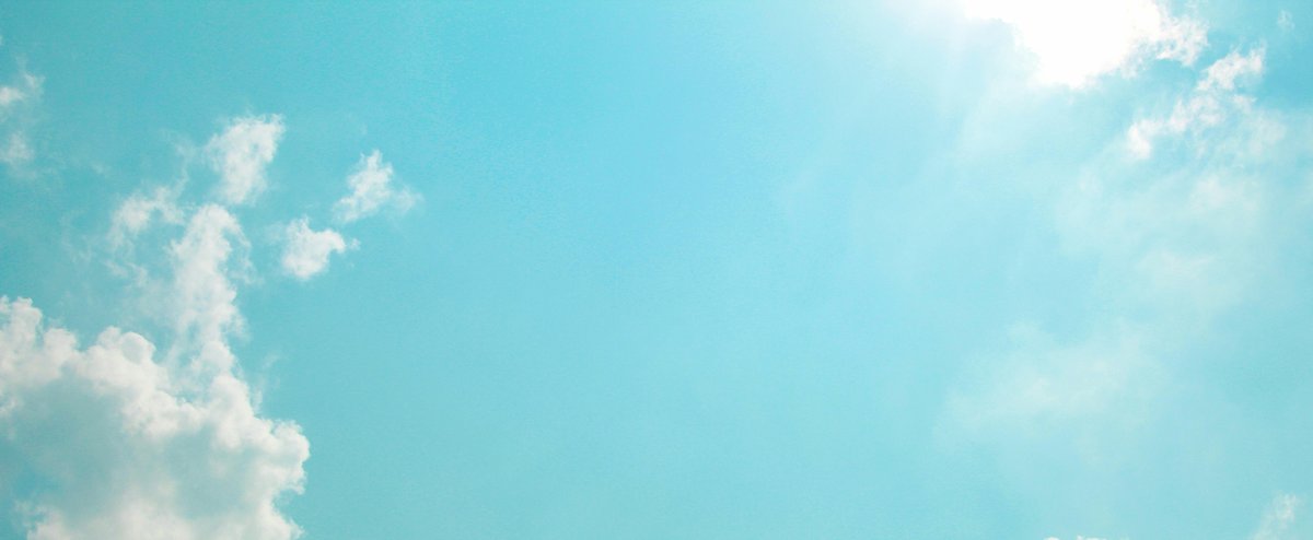 Sun breaking through clouds in a turquoise sky